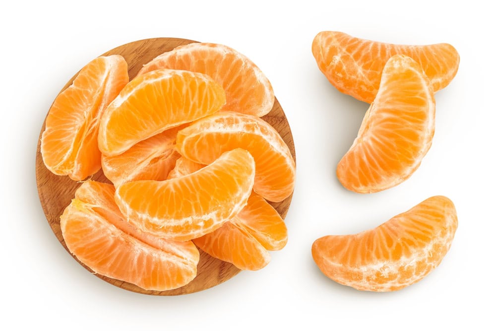clementine slices in wooden bowl isolated on white background