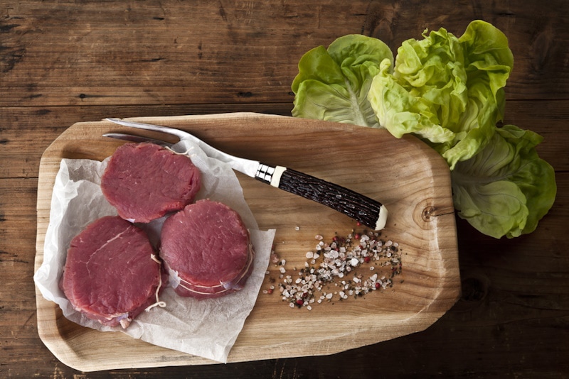 Beef bison fillet mignon cutlets on wooden plate