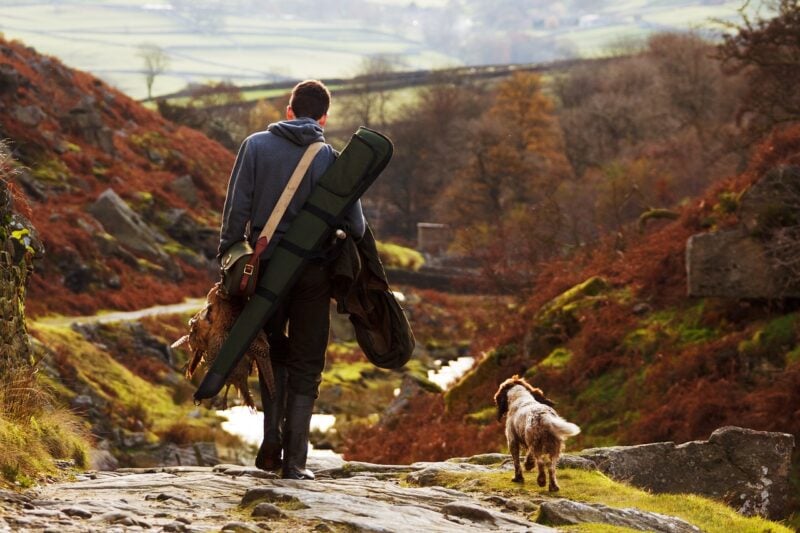 man-with-gun-and-hunting-dog