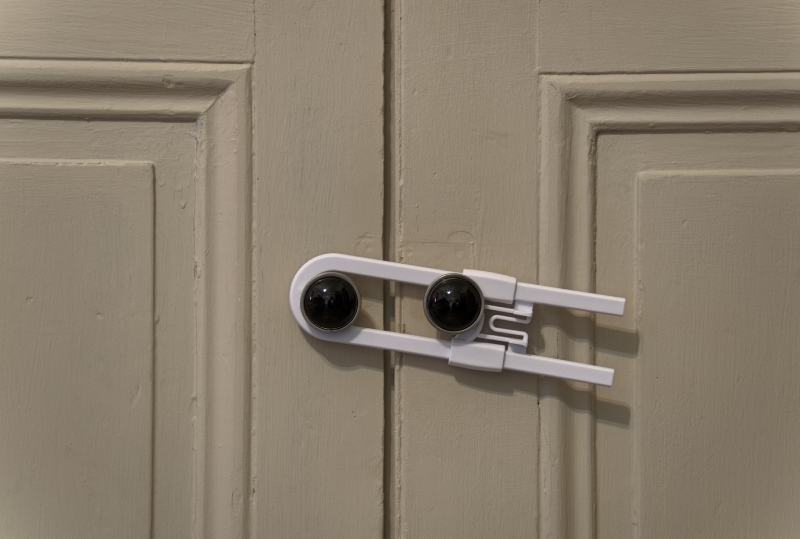 child safety lock holding two cabinet doors together