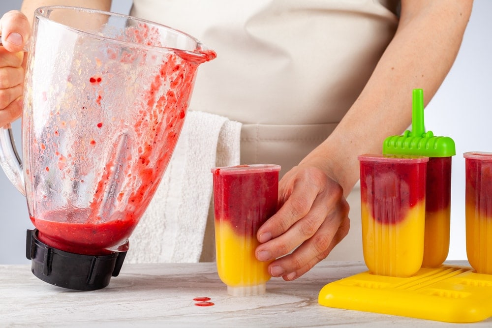 preparing homemade all natural fruit popsicles
