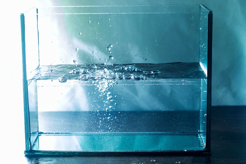Moving water waves and bubbles bursting in the aquarium
