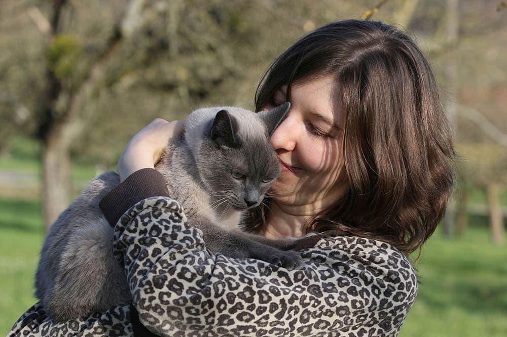 woman hugging a cat