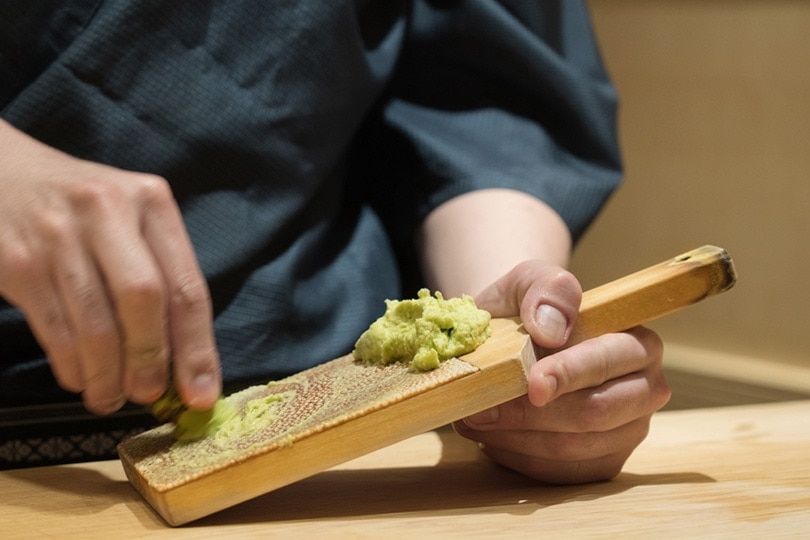 hand grating fresh wasabi with shark skin grater