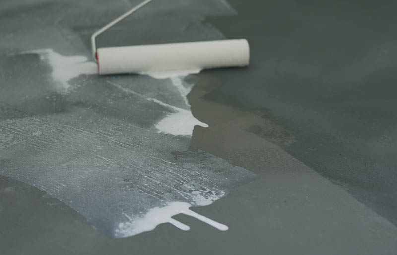 Closeup applying sealant on the concrete floor