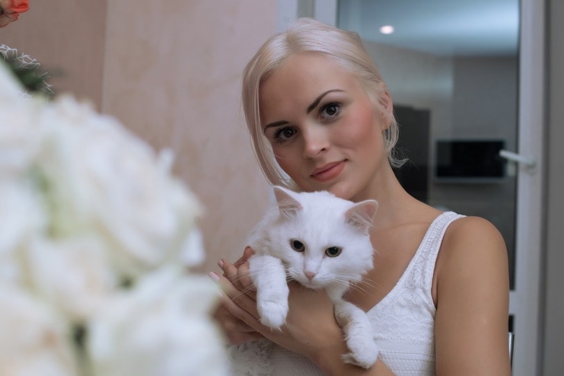 Woman holding a white cat