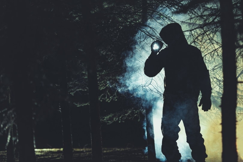 man using flashlight at night