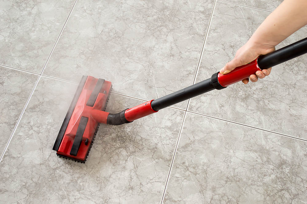 person mopping floor with steam mop