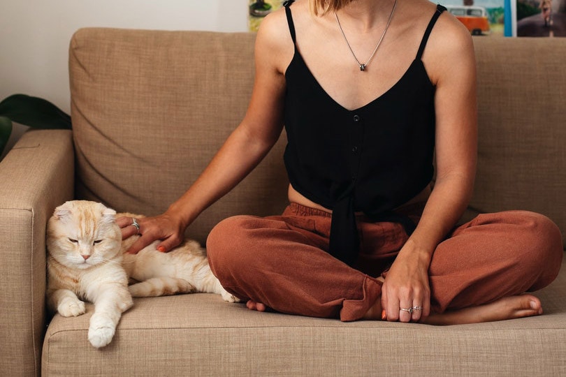 woman with cat on couch in a room
