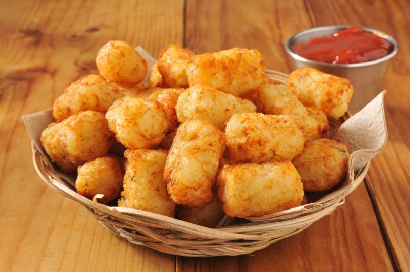basket of tater tots on a rustic wooden counter