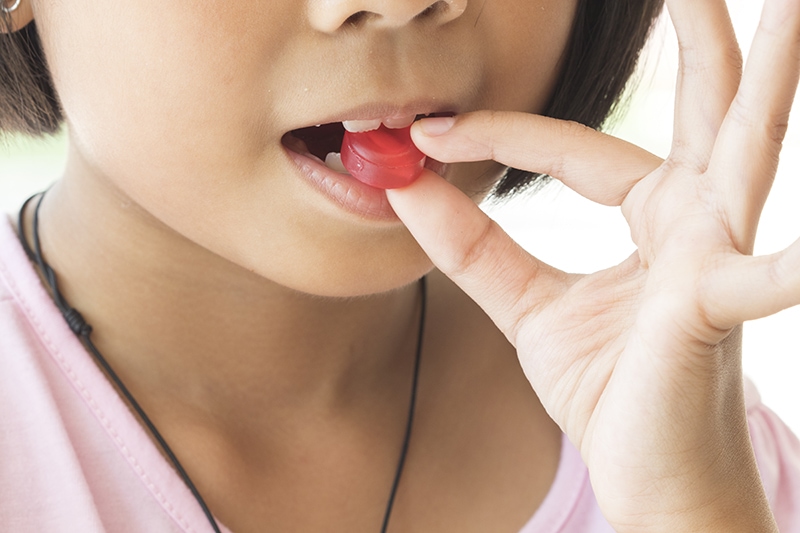 girl taking cough drop