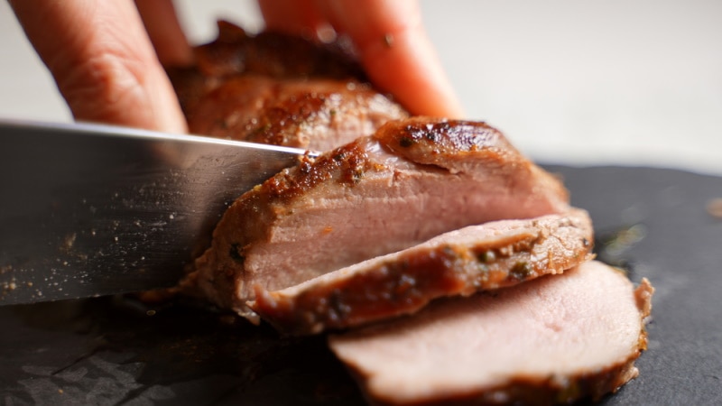 woman cuts duck fillet