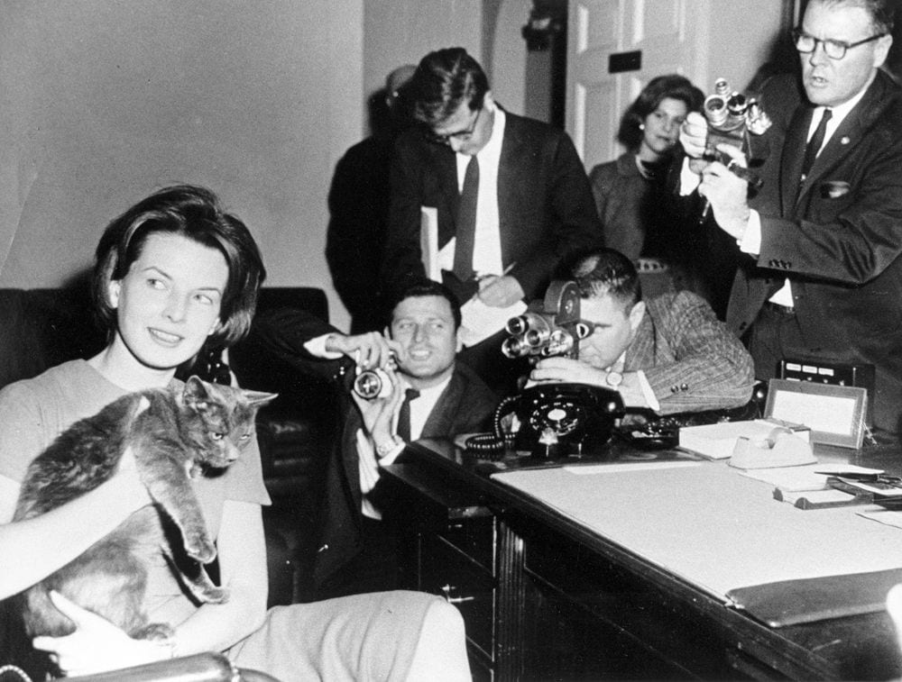 First Lady Jacqueline Kennedy's Press Secretary Pamela Turnure sits in an office holding Caroline Kennedy's cat, Tom Kitten