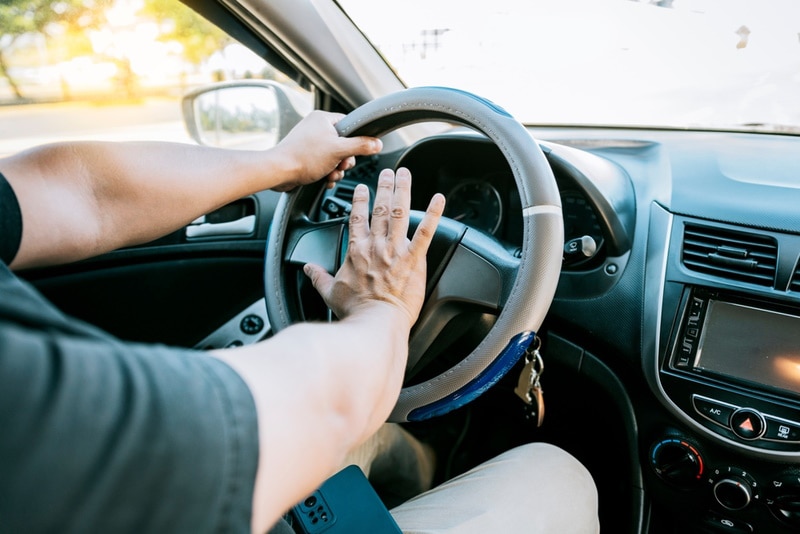 man honking car horn