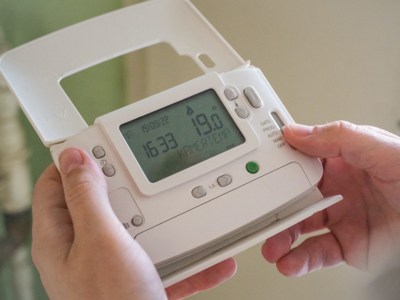 person adjusting thermostat