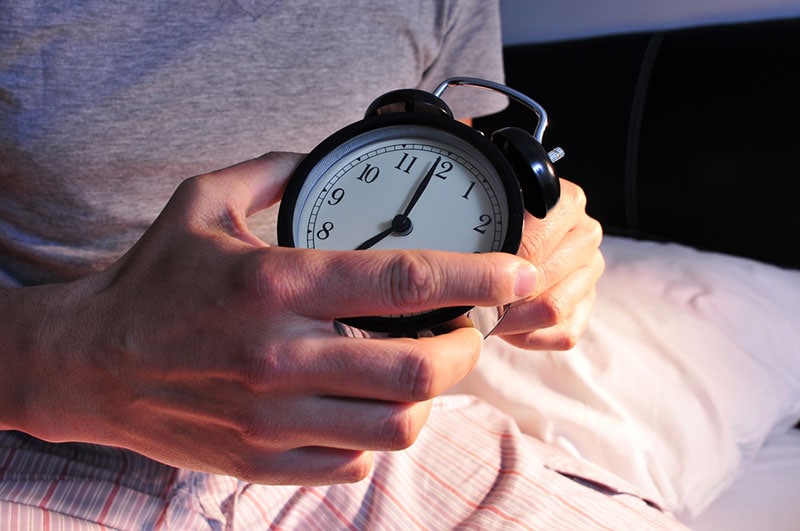 a man setting up the alarm clock