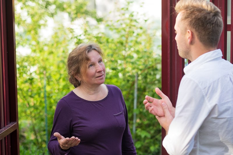 an elderly woman talking with a young man