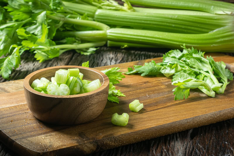 fresh celery on wooden board