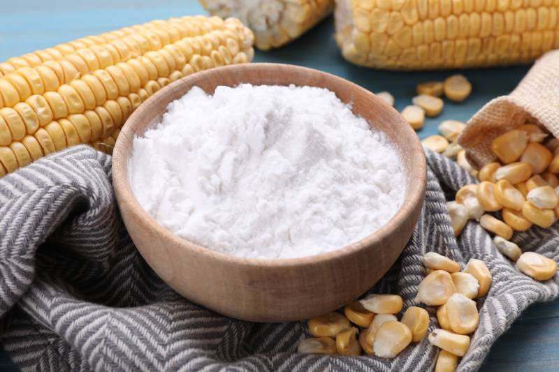 bowl with corn starch ripe cobs and kernels on table