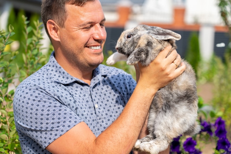 man holding lop eared rabbit