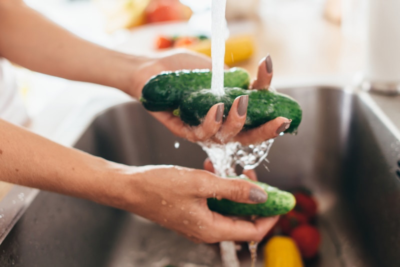 woman washing cucumbers