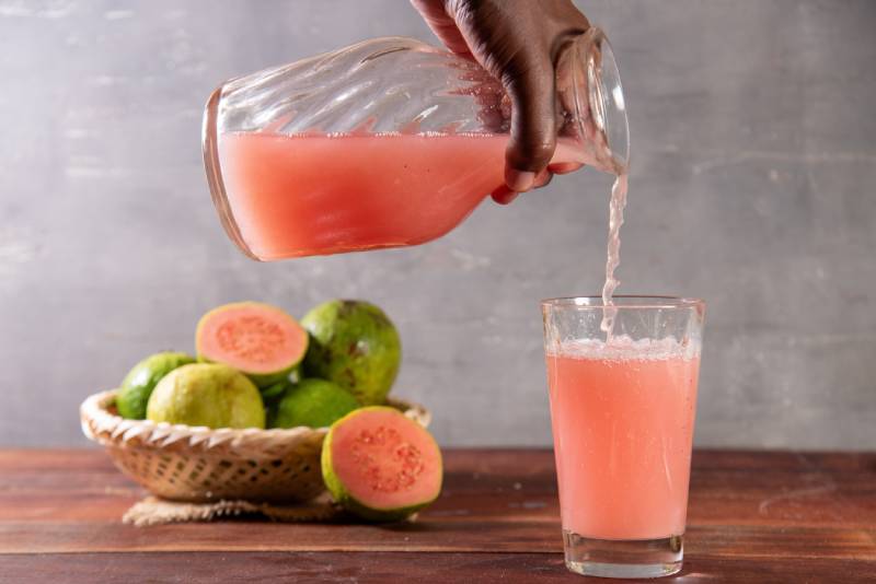 Jug of guava juice on rustic wooden table