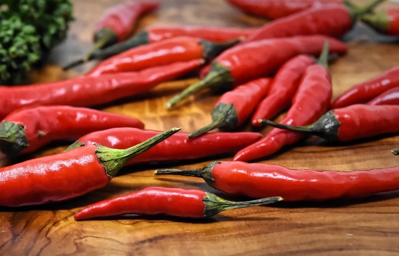 chili peppers on a wooden surface