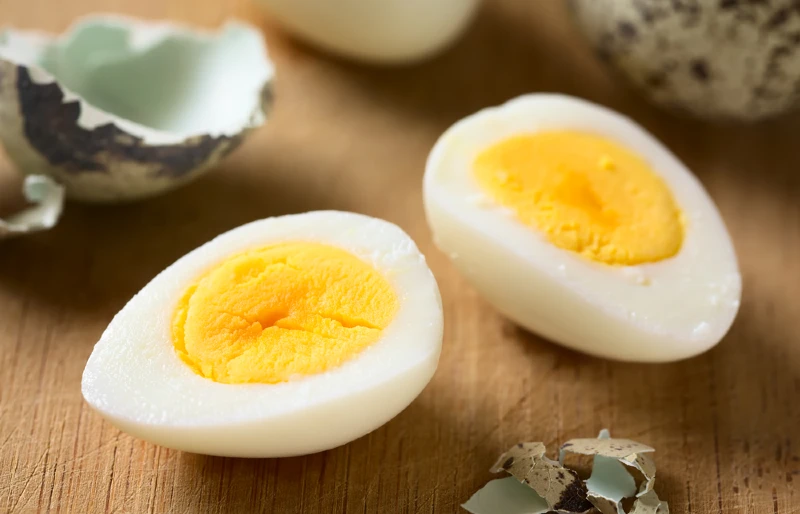 hard boiled quail egg halves on wooden board