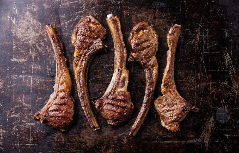 roasted lamb ribs meat on dark surface