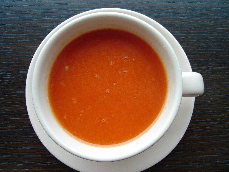 tomato soup in a cup on wooden table