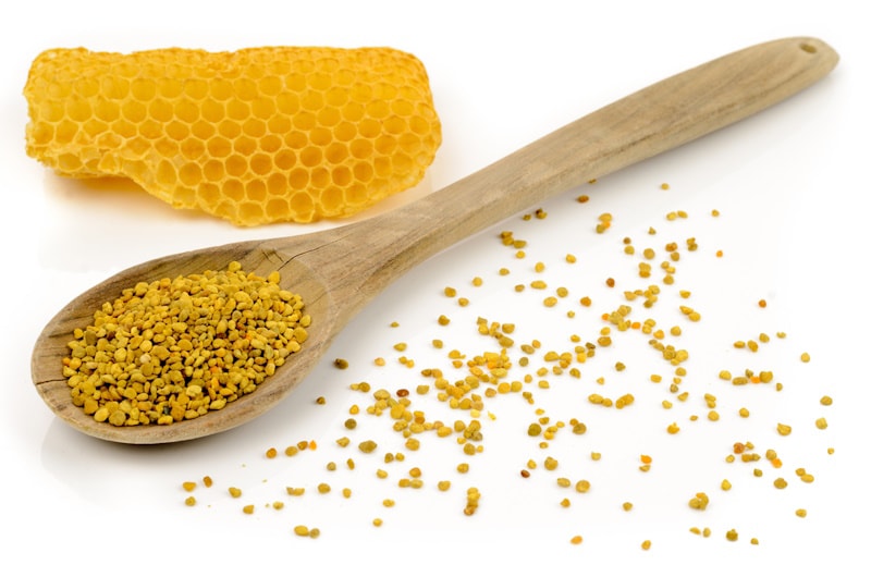 Bee pollen in wooden spoon and honeycomb