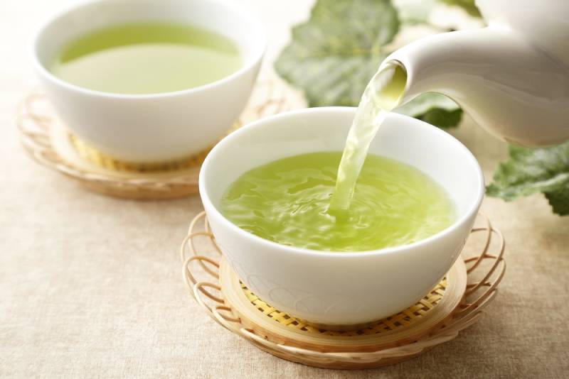 green tea pouring from pot to cup