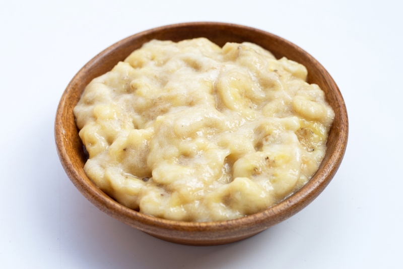 mashed banana in wooden bowl