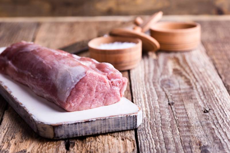 raw pork tenderloin on chopping board