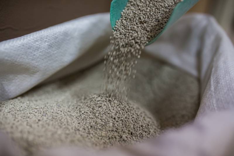 scooping cat litter in a large bag