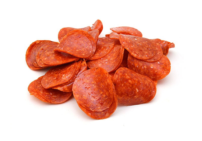 slices of pepperoni on white background