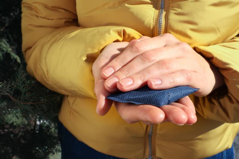 Woman holding hand warmer outdoors
