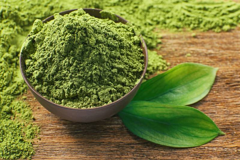 Powdered matcha green tea on wooden table