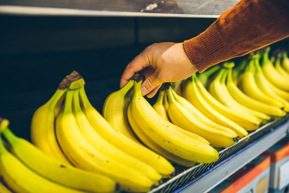 mans-hand-take-banana-from-shelf