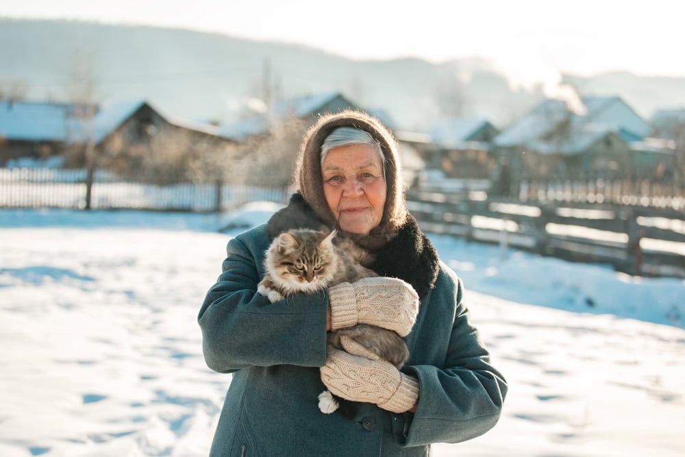 Russian grandmother holds a kitten in her arms