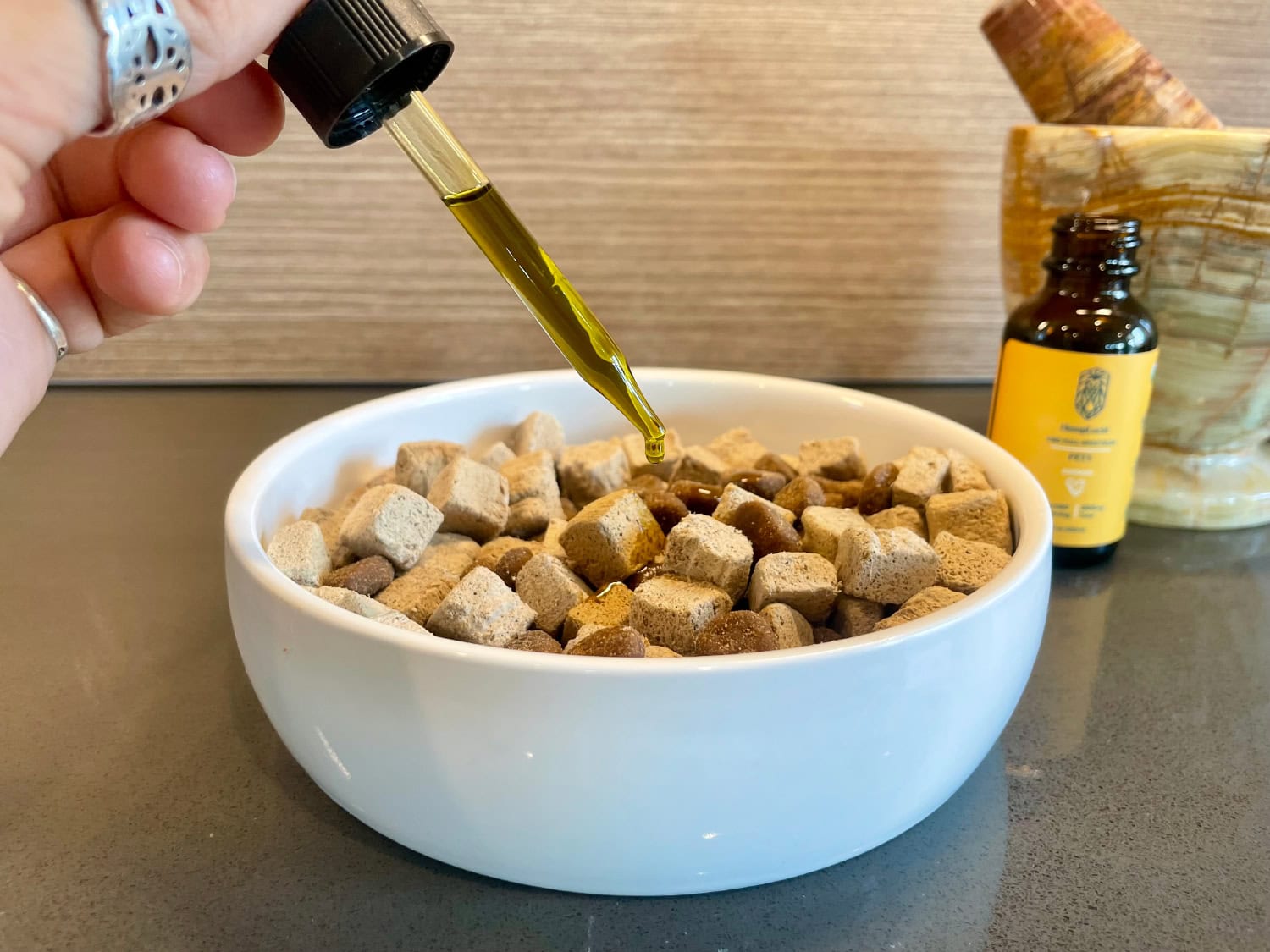 HempLucid Organic Full-Spectrum CBD - dropping CBD oil in the dog food